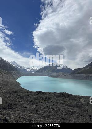 Lac glaciaire turquoise avec des montagnes enneigées sous un ciel dramatique en Nouvelle-Zélande Banque D'Images