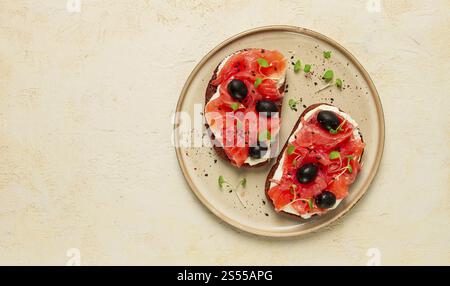 Sandwichs avec poisson rouge, fromage à la crème, olives et microgreens, petit déjeuner Banque D'Images