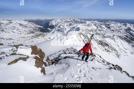Randonneurs de ski à pied, portant des skis sur un sac à dos, panorama de montagne, paysage de montagne enneigé en hiver, vue sur la vallée de Martell, haut tou Banque D'Images