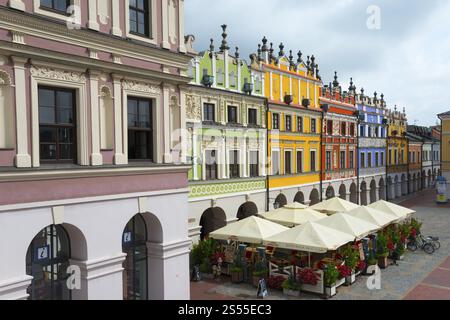 Bâtiments Renaissance colorés sur une place du marché ensoleillée avec des arcades et une atmosphère animée, Grande place du marché, Zamosc, Zamosc, UNESCO World Her Banque D'Images