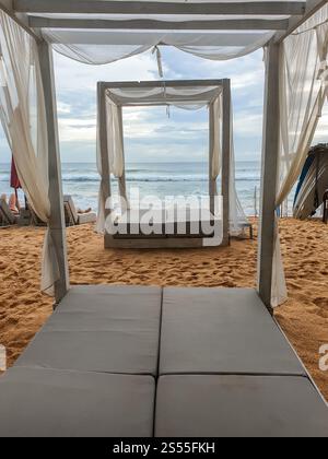 Belle photo de transats avec baldaquin sur la plage de l'océan. Belle image de chaises longues avec baldaquin sur la plage de l'océan Banque D'Images