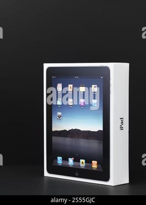 L'emballage des produits Apple iPad et en boîte enveloppée dans du plastique. Isolé sur fond noir. Banque D'Images