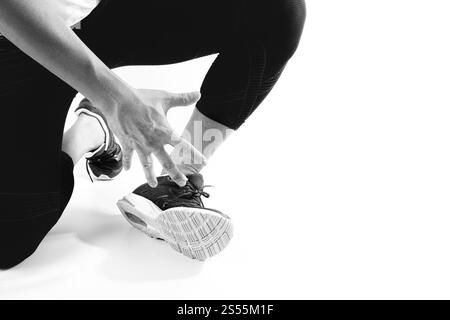 Coureur sportif tenant la cheville dans la douleur avec une blessure de sport de course de joint tordu cassé et athlétique homme touchant le pied en raison d'une entorse, noir et blanc Banque D'Images