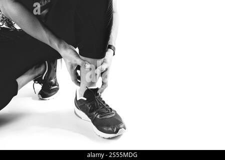 Runner holding sportif dans la cheville cassée avec douleur communs d'exploitation torsadée et blessures sportives Athletic man pied en raison d'entorses sur fond blanc Banque D'Images