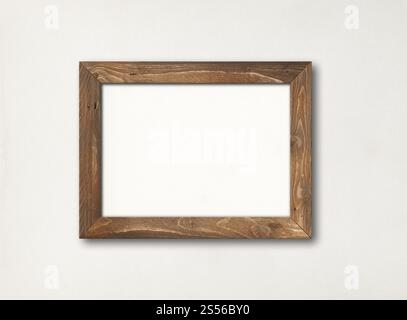 Vieux cadre en bois rustique brun accroché sur un mur blanc. Modèle de maquette vierge. Vieux cadre photo en bois rustique accroché à un mur blanc Banque D'Images
