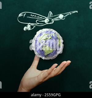 Part montrant avion avec du papier chiffonné comme symbole du monde concept on blackboard Banque D'Images
