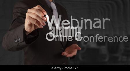 Businessman hand writing Webinaire avec fond papier froissé comme concept Banque D'Images
