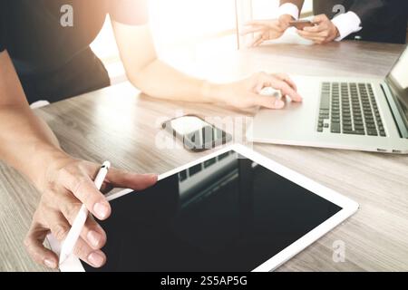 Deux collègues discuter d'affaires et des données d'écran vide et l'ordinateur tablette numérique portable avec smart phone sur le concept d'un bureau en bois Banque D'Images