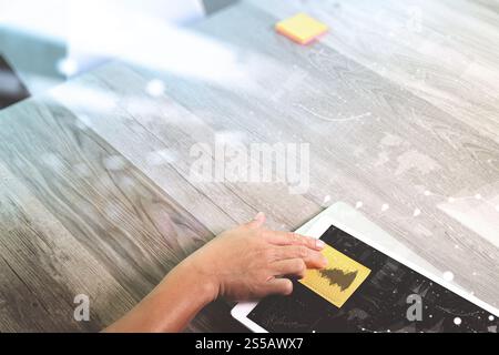 main d'homme d'affaires travaillant avec le papier de note de mémo sur tablette numérique et ordinateur portable. Couche graphique de stratégie d'entreprise. Sur le bureau en bois. Vue de dessus. Banque D'Images