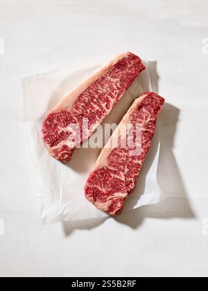Steak Wagyu cru frais australien sur la surface de la table de cuisine ensoleillée claire, vue de dessus Banque D'Images