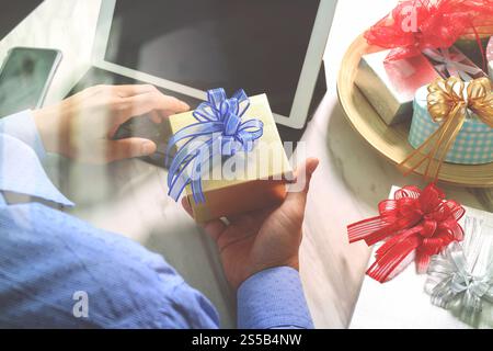 Cadeau donnant main créative choix et main avec cadeau. Livraison de cadeau, surprise, ordinateur tablette amarrant le téléphone intelligent clavier intelligent sur mable Banque D'Images