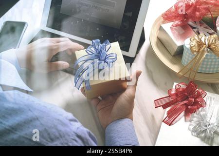 Cadeau donnant main créative choix et main avec cadeau. Livraison de cadeau, surprise, ordinateur tablette amarrant le téléphone intelligent clavier intelligent sur mable Banque D'Images