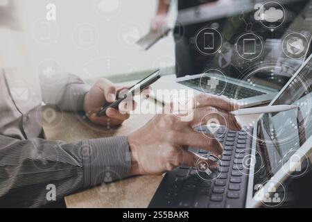 Designer Businessman la main à l'aide de smart phone mobile,paiement en ligne,shopping,omni channel digital tablet clavier d'ordinateur dans le bureau moderne Banque D'Images