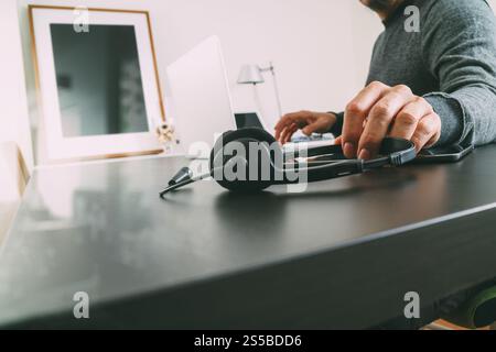 Homme utilisant un casque VoIP avec ordinateur latop sur le bureau dans le bureau moderne comme centre d'appels et concept de bureau d'assistance de service à la clientèle Banque D'Images