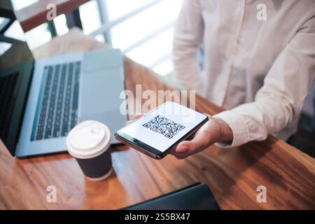 Paiement par code QR. Femme scannant le code QR concept de technologie Cashless d'achat en ligne Banque D'Images