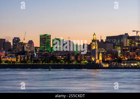Vieux-Port de Montréal et horizon du centre-ville la nuit. Les lumières colorées des bâtiments se reflètent dans l'eau. Montréal, Québec, Canada. Tour d'horloge. Banque D'Images