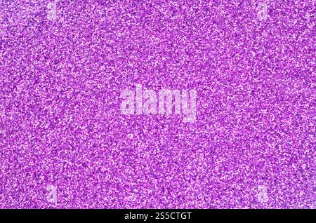 Sequins décoratifs violets. Image d'arrière-plan avec des lumières bokeh brillantes provenant de petits éléments qui réfléchissent la lumière. Sequins décoratifs violets. Arrière-plan Banque D'Images
