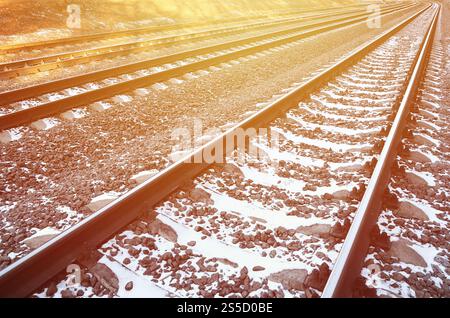 Détails chemin de fer d'hiver russe enneigé sous la lumière du soleil. Les rails et les traverses sous la neige de décembre. Chemins de fer russes en détail. Hiver Banque D'Images