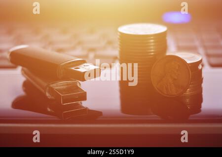 Cartes flash USB couchées sur le boîtier noir de l'ordinateur portable devant son clavier. Le concept de gagner sur Internet, monétisation en ligne et paiement de Banque D'Images