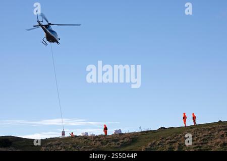 Arthur's Seat Édimbourg, Écosse, Royaume-Uni. 14 janvier 2025. Un hélicoptère effectuant plusieurs voyages pour livrer du matériel en préparation pour réparer le chemin en zig zag qui mène du parc Holyrood jusqu'à juste en dessous du sommet du lieu touristique populaire, le nombre enrmous de visiteurs au parc Holyrood provoque une érosion constante des chemins du parc. Pour des raisons de sécurité, la High Road et le trottoir seront partiellement fermés du 14 au 17 janvier 2025 0800 au 1600. Credit : Arch White/Alamy Live news Banque D'Images