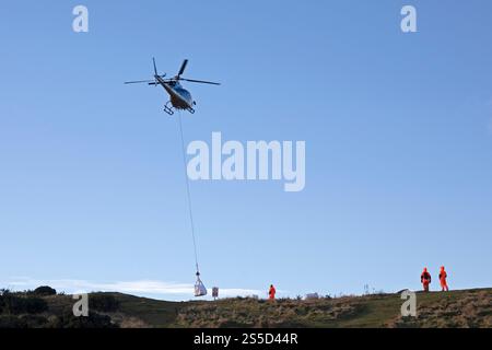 Arthur's Seat Édimbourg, Écosse, Royaume-Uni. 14 janvier 2025. Un hélicoptère effectuant plusieurs voyages pour livrer du matériel en préparation pour réparer le chemin en zig zag qui mène du parc Holyrood jusqu'à juste en dessous du sommet du lieu touristique populaire, le nombre enrmous de visiteurs au parc Holyrood provoque une érosion constante des chemins du parc. Pour des raisons de sécurité, la High Road et le trottoir seront partiellement fermés du 14 au 17 janvier 2025 0800 au 1600. Credit : Arch White/Alamy Live news Banque D'Images