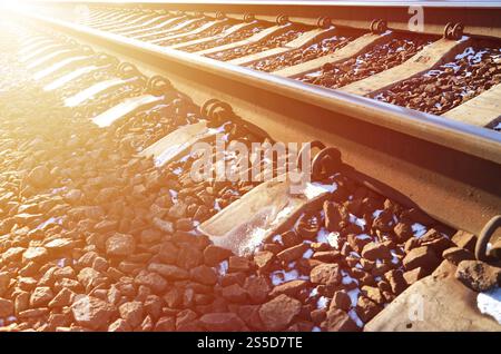Détails chemin de fer d'hiver russe enneigé sous la lumière du soleil. Les rails et les traverses sous la neige de décembre. Chemins de fer russes en détail. Hiver Banque D'Images