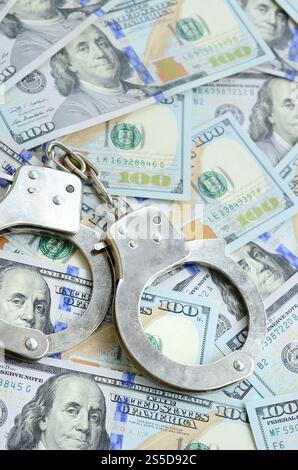 Les menottes de police argentées se trouvent sur de nombreux billets d'un dollar. Les menottes de police argentées se trouvent sur de nombreux billets d'un dollar Banque D'Images