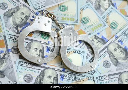 Les menottes de police argentées se trouvent sur de nombreux billets d'un dollar. Les menottes de police argentées se trouvent sur de nombreux billets d'un dollar Banque D'Images