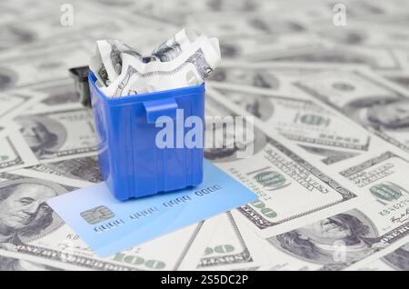 Billets d'un dollar jetés à la poubelle et carte bancaire. Le concept de transfert et de stockage de fonds dans une monnaie virtuelle. Banques modernes. Concept de Banque D'Images