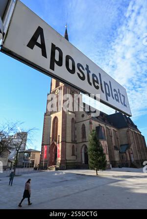 Viernheim, Allemagne. 14 janvier 2025. L'église apôtre catholique peut être vue derrière le panneau 'Apostelplatz'. Aucun feu d'artifice ne peut être déclenché dans certaines parties du centre-ville de Viernheim la veille du nouvel an. Cela a été décidé par le conseil municipal de la ville de Hesse du Sud. Plus précisément, la zone autour de l'église de l'Apôtre et la zone environnante est touchée. Crédit : Arne Dedert/dpa/Alamy Live News Banque D'Images