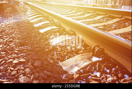 Détails chemin de fer d'hiver russe enneigé sous la lumière du soleil. Les rails et les traverses sous la neige de décembre. Chemins de fer russes en détail. Hiver Banque D'Images