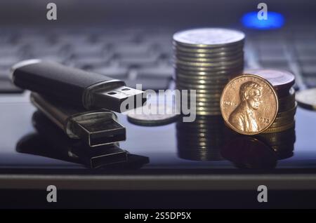 Cartes flash USB couchées sur le boîtier noir de l'ordinateur portable devant son clavier. Le concept de gagner sur Internet, monétisation en ligne et paiement de Banque D'Images