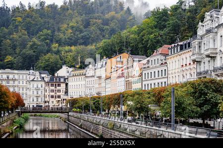 Ville thermale historique de Karlovy Vary avec ses façades élégantes et ses collines verdoyantes le long de la promenade aux couleurs d'automne sur la rivière Carlsbad, République tchèque 2024- Banque D'Images