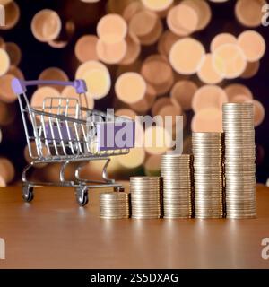 Panier vide et piles d'argent dans le graphique de croissance sur fond de lumières de noël bokeh colorées. Concept de période de magasinage. Panier vide Banque D'Images