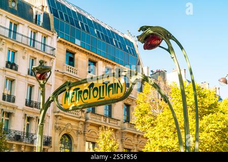 Vintage Metropolitain signe à Paris avec lampadaires classiques et un bâtiment moderne en arrière-plan sur une journée ensoleillée, France Banque D'Images