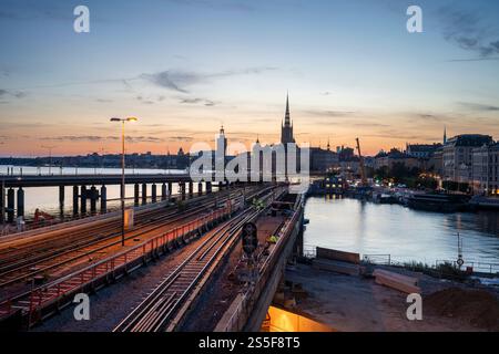 Coucher de soleil sur la ville de Stockholm avec une vue sur les voies ferrées, le chantier de construction et l'horizon historique de Gamla Stan la vieille ville, Stockholm Banque D'Images