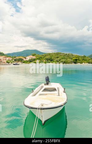 Bateau ancré à un quai avec verdure luxuriante et montagnes dans le fond et l'eau bleu turquoise de la mer Adriatique, Mali Ston, Croatie Banque D'Images