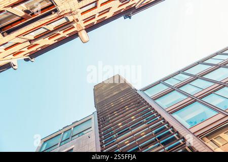 Vue vers le haut des immeubles modernes de grande hauteur contre un ciel bleu clair avec un lampadaire visible dans le centre de Stockholm, Suède Banque D'Images