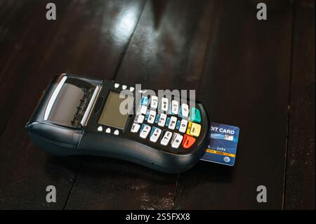 Machine à cartes ou terminal pos avec carte de crédit insérée sur table en bois Banque D'Images