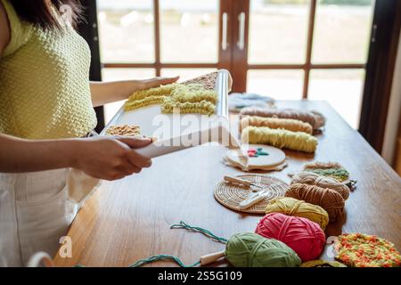 Aiguille perforée. Femme asiatique faisant tricoter Hobby à la main dans l'atelier de studio. Designer Workplace projet artisanal fait à la main concept de broderie DIY Banque D'Images