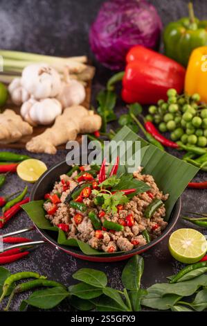 Basilic de porc sauté sur feuilles de banane dans une poêle. Cuisine thaïlandaise. Banque D'Images