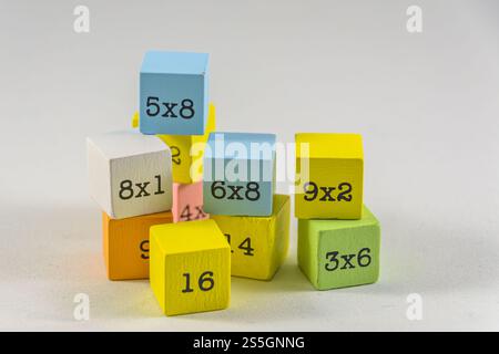 Une paire de blocs de table de multiplication en bois colorés sur un fond blanc. Palme d'éducation pour enfant Banque D'Images