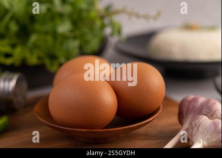 Trois œufs de poule dans l'assiette avec de l'ail. Mise au point sélective. Banque D'Images