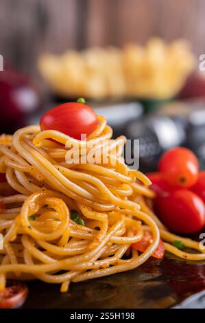 Spaghetti dans une tasse noire avec tomates et laitue. Mise au point sélective. Banque D'Images
