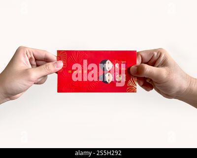 Deux mains donnant des enveloppes rouges chinoises, également connues sous le nom de hongbao ou angpao. Il est rempli d'argent, et célèbre pour le nouvel an chinois ou le nouvel an lunaire. Banque D'Images