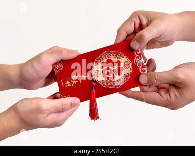 Deux mains donnant des enveloppes rouges chinoises, également connues sous le nom de hongbao ou angpao. Il est rempli d'argent, et célèbre pour le nouvel an chinois ou le nouvel an lunaire. Banque D'Images