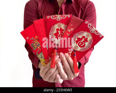 Un homme asiatique tenant des enveloppes rouges chinoises, également connu sous le nom de hongbao ou angpao. L'enveloppe rouge est remplie d'argent et célèbre pour le nouvel an chinois. Banque D'Images