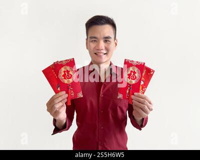 Un homme asiatique tenant des enveloppes rouges chinoises, également connu sous le nom de hongbao ou angpao. L'enveloppe rouge est remplie d'argent et célèbre pour le nouvel an chinois. Banque D'Images
