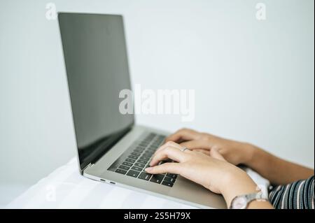 Une main pour femme placée sur un ordinateur portable. Mise au point sélective. Banque D'Images