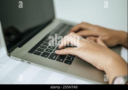 Une main pour femme placée sur un ordinateur portable. Mise au point sélective. Banque D'Images